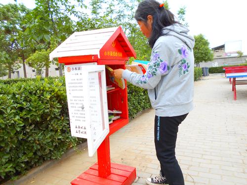 新郑新村水泉小学毛林英在整理校园书橱