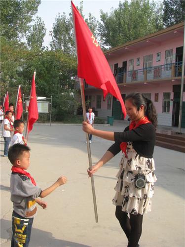 3惠济区八堡小学毛广慧在入队仪式上向新建中队授中队旗